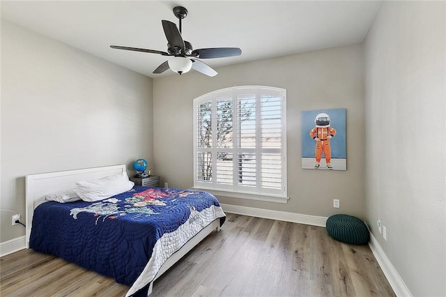 bedroom featuring baseboards, a ceiling fan, and wood finished floors