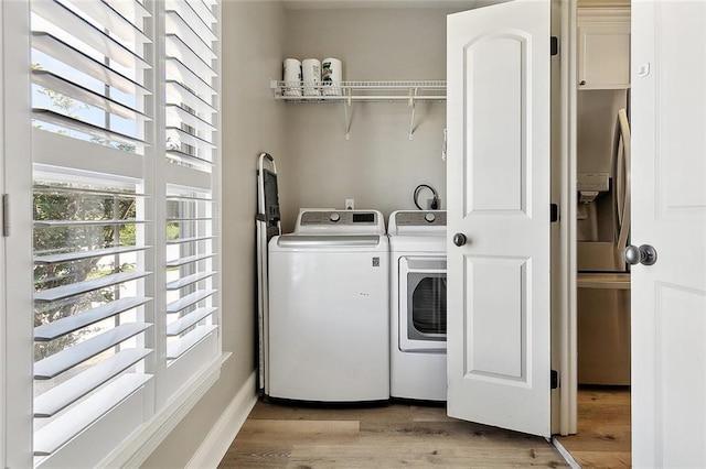 washroom featuring laundry area, light wood finished floors, and washing machine and clothes dryer
