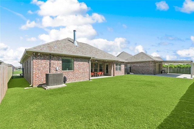 rear view of property with a fenced backyard, central AC, a patio area, and brick siding