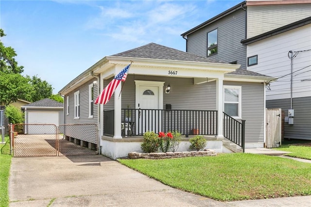 view of front of property featuring a front lawn, roof with shingles, and covered porch