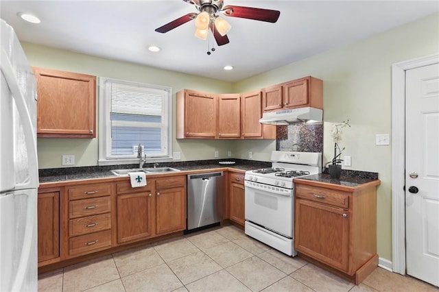 kitchen with light tile patterned flooring, white appliances, tile counters, under cabinet range hood, and a sink