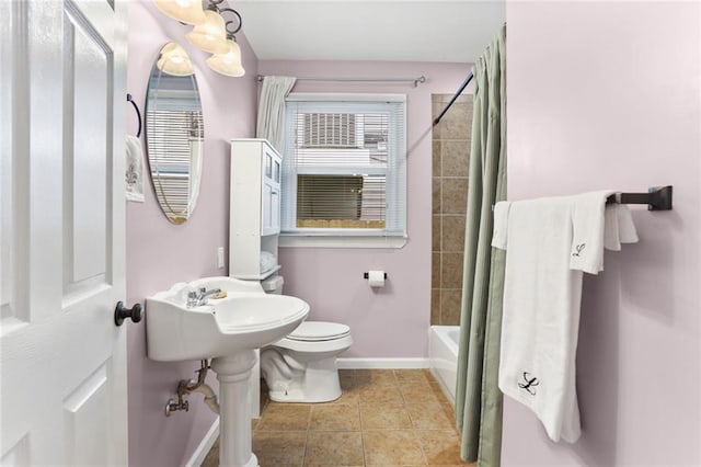 full bathroom with tile patterned floors, baseboards, shower / bath combo with shower curtain, and toilet