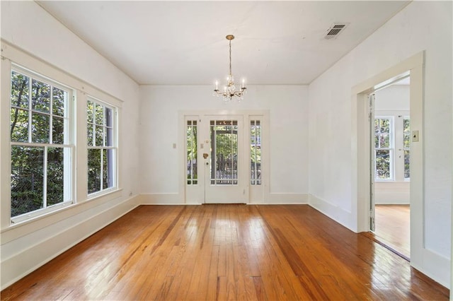 328 E St, Mandeville, LA 70448 - unfurnished dining area featuring baseboards, a chandelier, visible vents, and light wood-type flooring