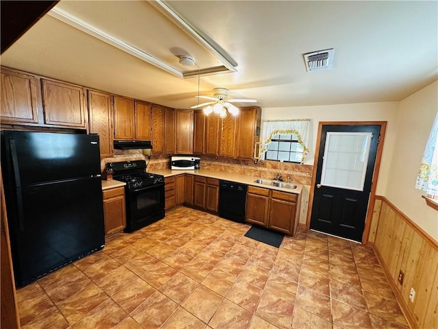 kitchen with visible vents, brown cabinets, light countertops, black appliances, and under cabinet range hood