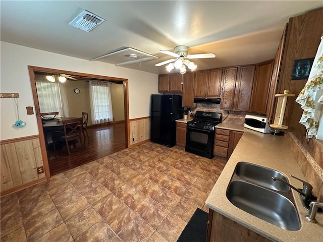 kitchen with visible vents, light countertops, ventilation hood, a sink, and black appliances
