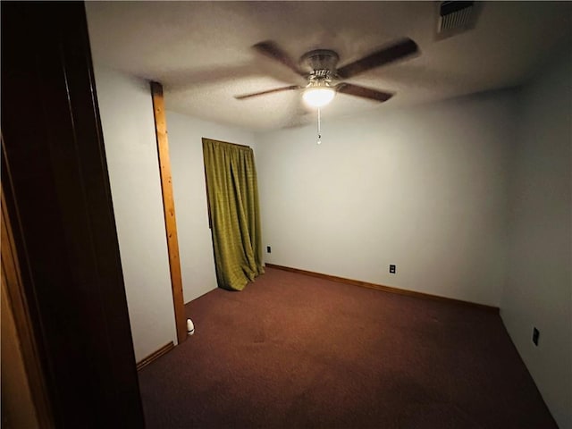 carpeted empty room featuring ceiling fan and visible vents