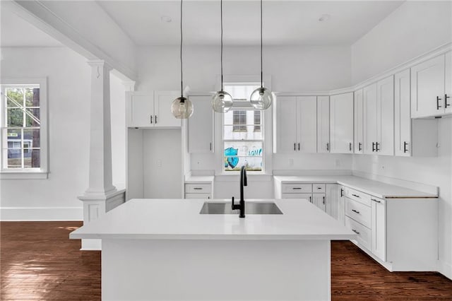 180002 Franklin Ave, New Orleans, LA 70117 - kitchen featuring dark wood finished floors, white cabinetry, an island with sink, light countertops, and hanging light fixtures