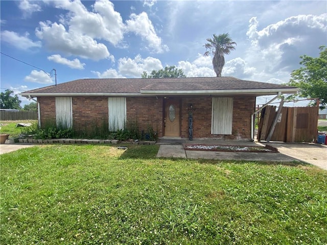 ranch-style home featuring a porch, a front lawn, fence, and brick siding