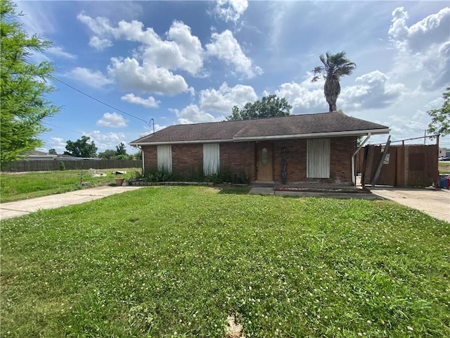 ranch-style house with brick siding, fence, covered porch, and a front yard