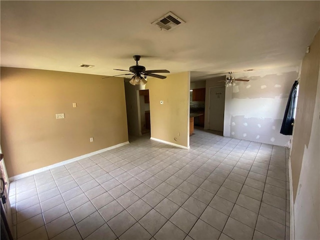 tiled spare room featuring a ceiling fan, baseboards, and visible vents