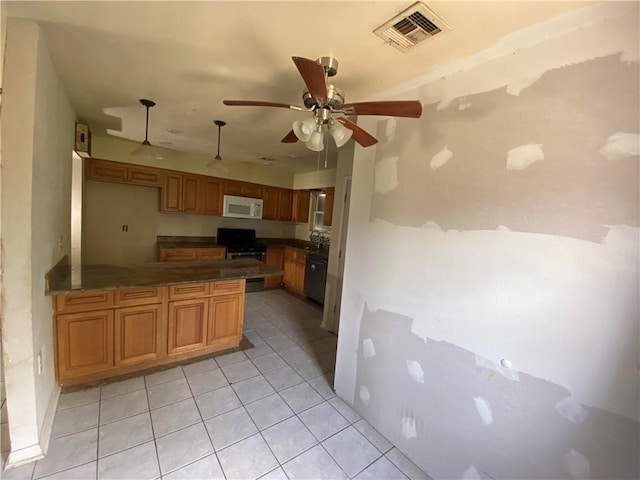 kitchen with visible vents, dark countertops, stainless steel range with gas stovetop, white microwave, and a peninsula