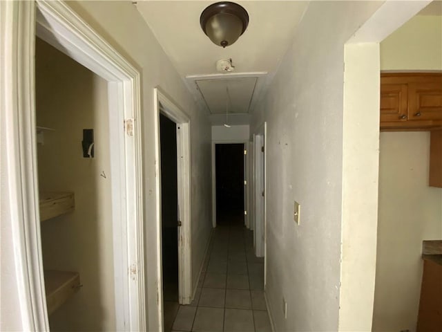 hall featuring attic access and light tile patterned floors
