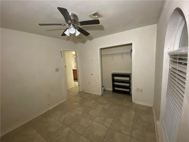 unfurnished bedroom featuring ceiling fan, tile patterned flooring, baseboards, visible vents, and a closet
