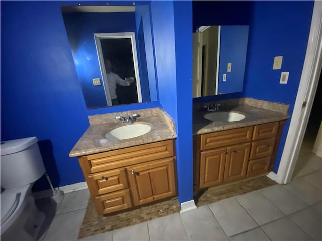 bathroom featuring a sink, two vanities, tile patterned floors, and toilet