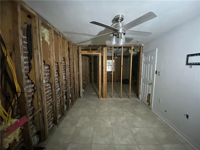 misc room featuring baseboards, ceiling fan, and light tile patterned floors
