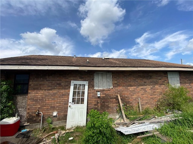 back of property featuring brick siding