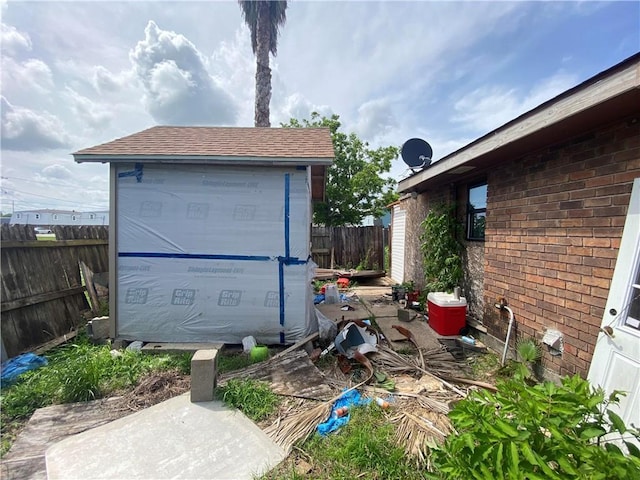 exterior space with a storage unit and fence
