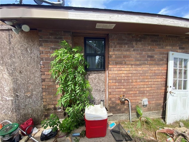 view of exterior entry with brick siding