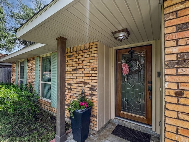 view of exterior entry featuring brick siding