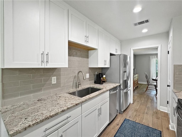 kitchen with visible vents, a sink, white cabinetry, and appliances with stainless steel finishes
