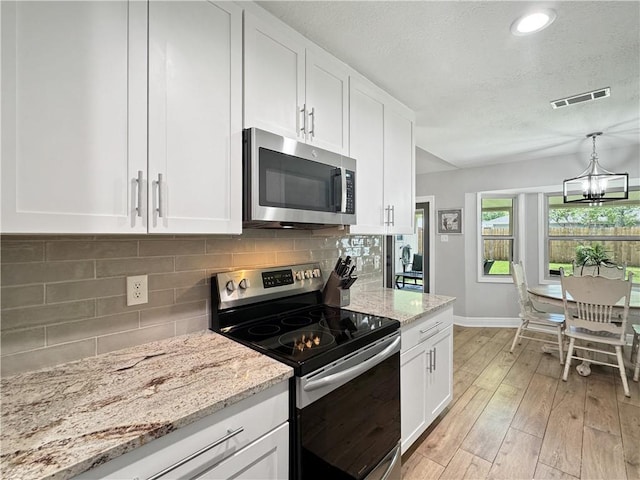 kitchen featuring white cabinets, baseboards, appliances with stainless steel finishes, and visible vents