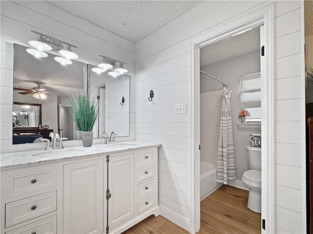 bathroom with double vanity, a textured ceiling, and a sink