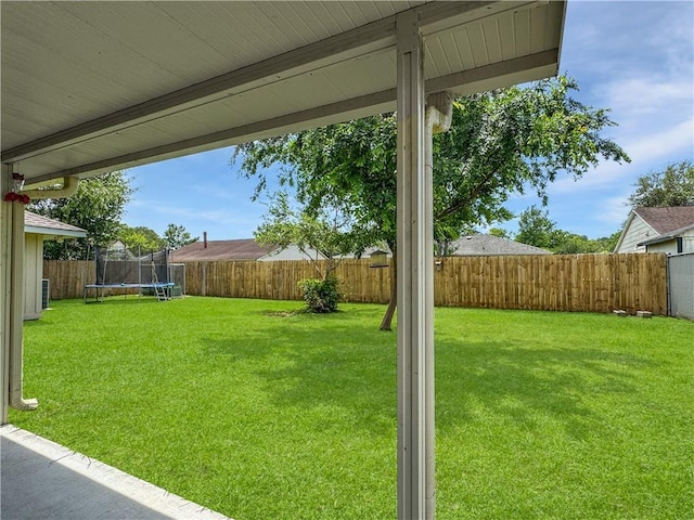 view of yard featuring a fenced backyard and a trampoline