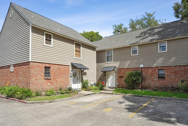 1500 W Esplanade Ave Unit 22B, Kenner, LA 70065 - rear view of property featuring brick siding and uncovered parking