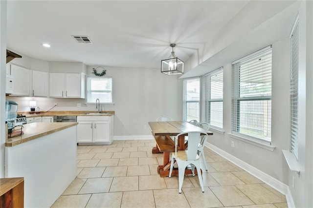 202 River Point Dr, Destrehan, LA 70047 - kitchen with a sink, baseboards, white cabinets, and light tile patterned flooring
