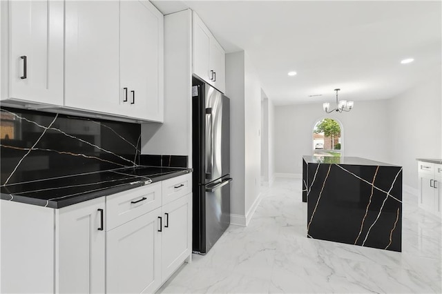 736 Glouster Pl, Gretna, LA 70056 - kitchen with white cabinets, dark countertops, an inviting chandelier, stainless steel fridge, and marble finish floor