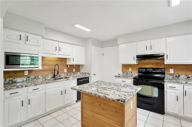 kitchen with a sink, light tile patterned flooring, under cabinet range hood, and black appliances