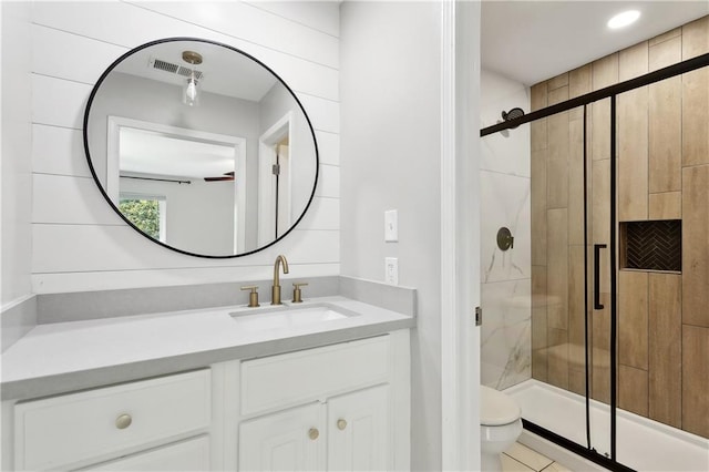 bathroom featuring toilet, visible vents, a shower stall, and vanity