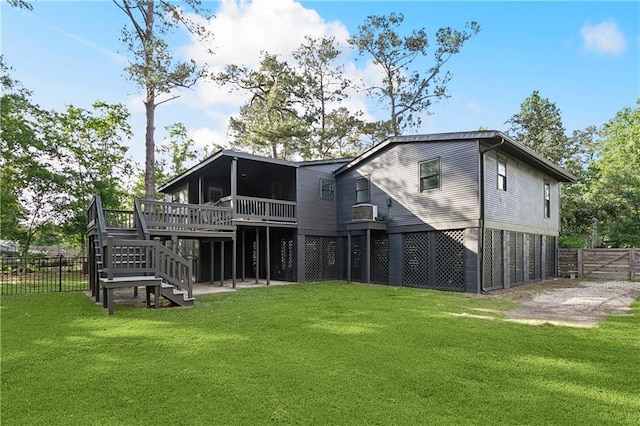 back of house featuring stairs, a wooden deck, a yard, and fence