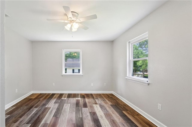 unfurnished room featuring baseboards, dark wood-style flooring, a ceiling fan, and a healthy amount of sunlight