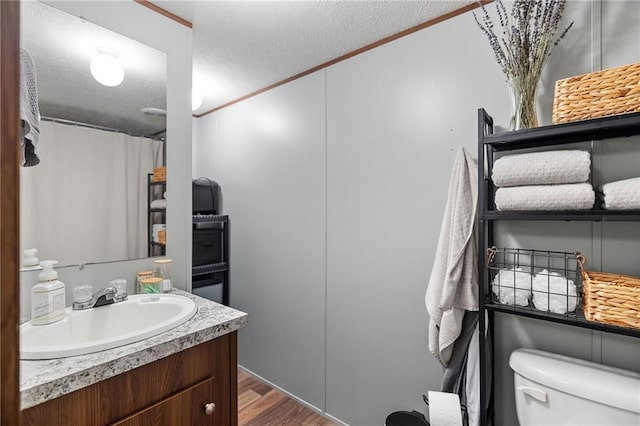 26272 Jim Bailey Rd, Holden, LA 70744 - full bathroom featuring toilet, a textured ceiling, wood finished floors, and vanity