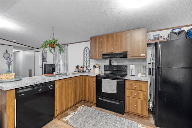 26272 Jim Bailey Rd, Holden, LA 70744 - kitchen featuring light wood finished floors, a peninsula, under cabinet range hood, and black appliances