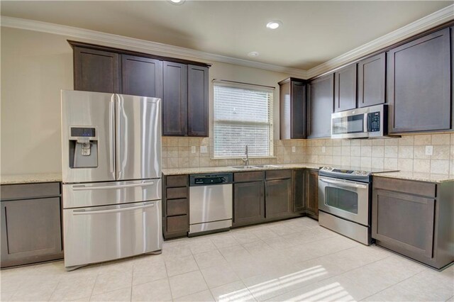 257 Long Leaf Ct, Ponchatoula, LA 70454 - kitchen featuring appliances with stainless steel finishes, a sink, crown molding, dark brown cabinetry, and tasteful backsplash