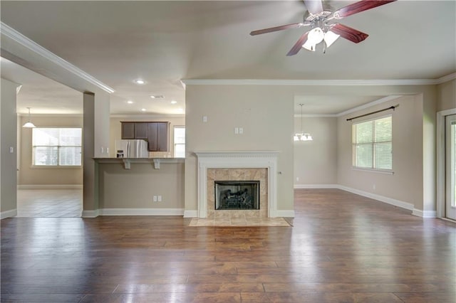 unfurnished living room with ornamental molding, dark wood-type flooring, and a wealth of natural light