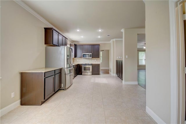 kitchen featuring ceiling fan, appliances with stainless steel finishes, tasteful backsplash, dark brown cabinets, and light countertops