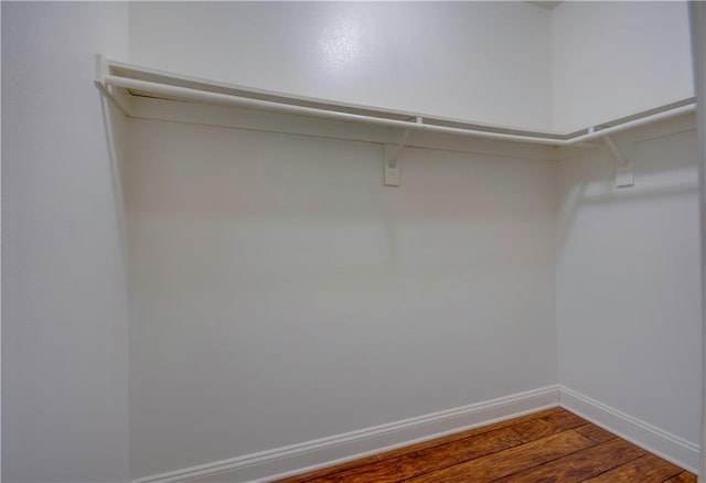 walk in closet with wood finished floors