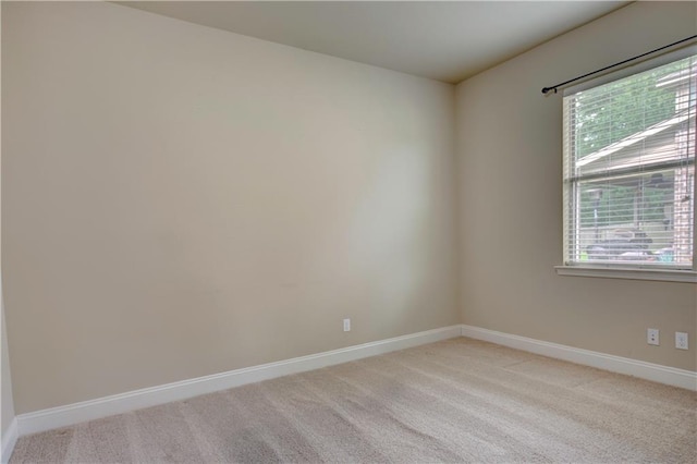 empty room with baseboards and light carpet