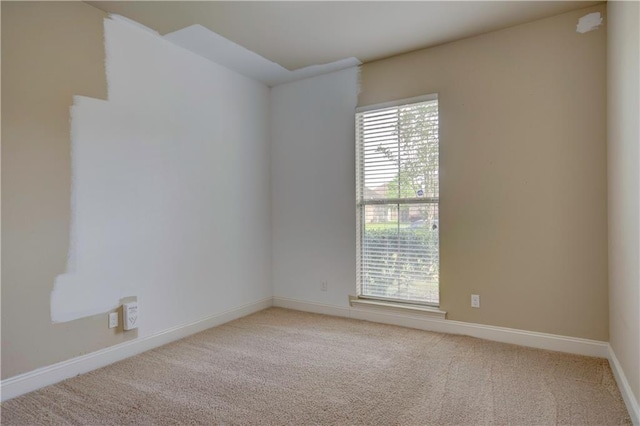 spare room featuring carpet flooring and baseboards