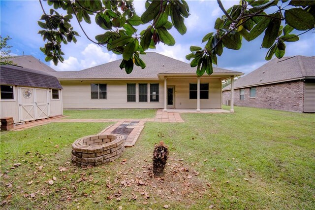 257 Long Leaf Ct, Ponchatoula, LA 70454 - back of property with an outdoor fire pit, a patio area, a storage shed, an outdoor structure, and a yard