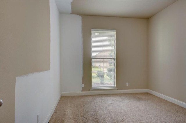 carpeted empty room with baseboards