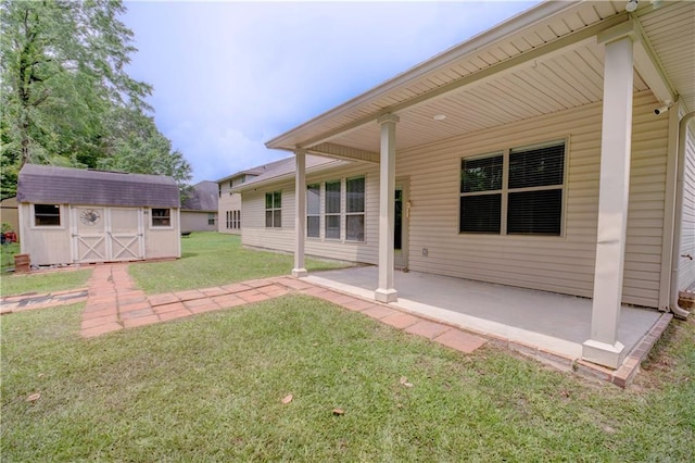 rear view of house featuring a patio, an outdoor structure, a shed, and a yard