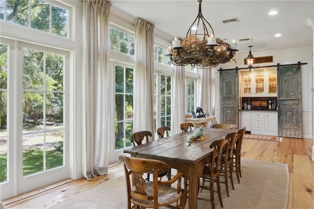 16407 Summerhill Rd, Covington, LA 70435 - dining space with a barn door, light wood-type flooring, a chandelier, and recessed lighting