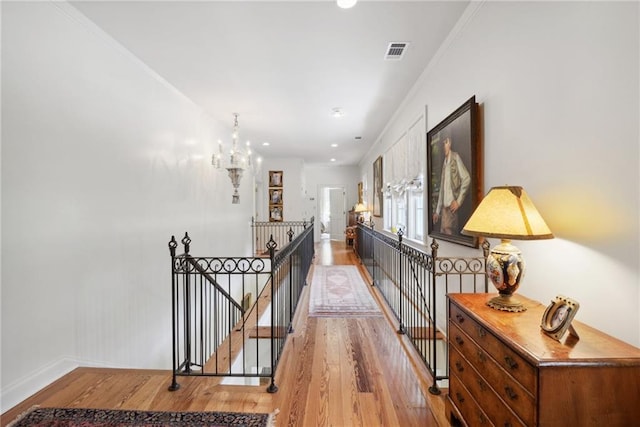 16407 Summerhill Rd, Covington, LA 70435 - corridor with an upstairs landing, wood finished floors, a chandelier, baseboards, and ornamental molding