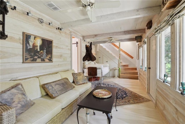 16407 Summerhill Rd, Covington, LA 70435 - living area featuring wood walls, a ceiling fan, stairs, beamed ceiling, and light wood-style flooring