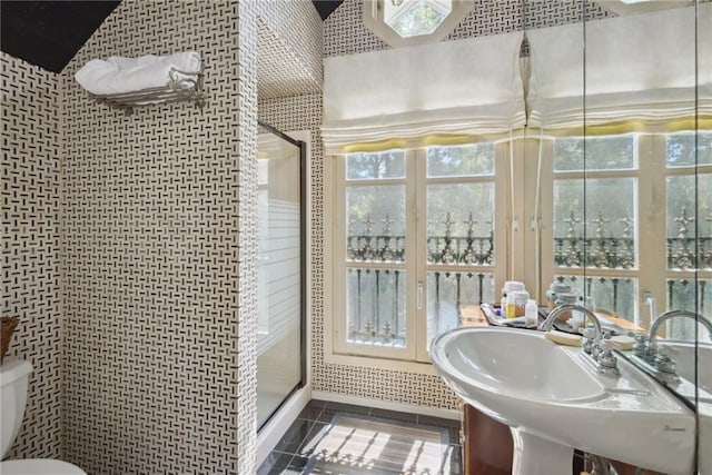 16407 Summerhill Rd, Covington, LA 70435 - bathroom featuring toilet, a stall shower, tile patterned flooring, a sink, and healthy amount of natural light