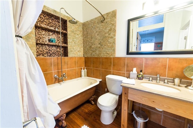 1418 Kerlerec St, New Orleans, LA 70116 - full bathroom featuring a washtub, tile walls, wood finished floors, vanity, and toilet